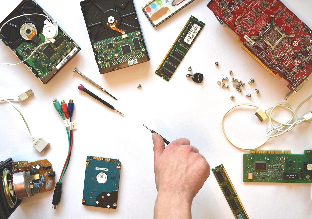 A hand sorting through disassembled device parts